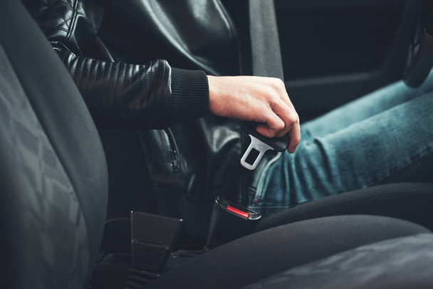 transportation and vehicle concept - man fastening seat belt in car - Fotoğraf, Görsel