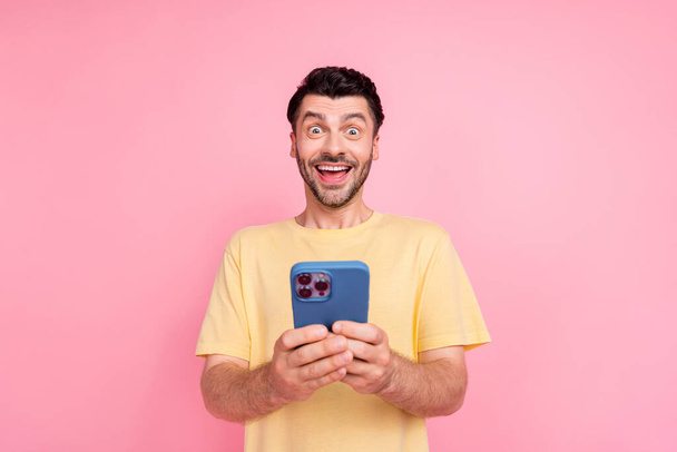 Photo of positive nice man use modern device gadget rejoice fast 4g connection million followers blog isolated on pink color background. - Foto, Bild
