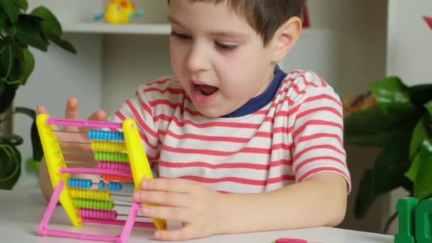 Пятилетний мальчик учится рассчитывать на счеты, математику, арифметику для дошкольников - Кадры, видео
