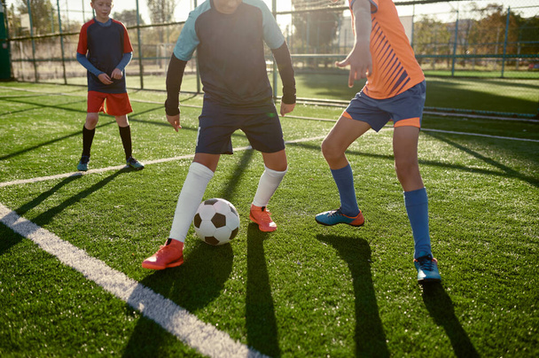 Jovens rapazes a jogar futebol no campo de treino para crianças. Torneio de esportes para a equipe de jovens - Foto, Imagem