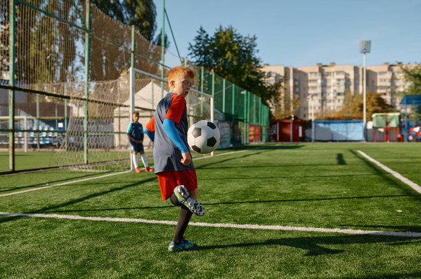 Kids playing soccer game, young boy footballer wearing uniform hitting ball. School outdoor stadium - Photo, Image