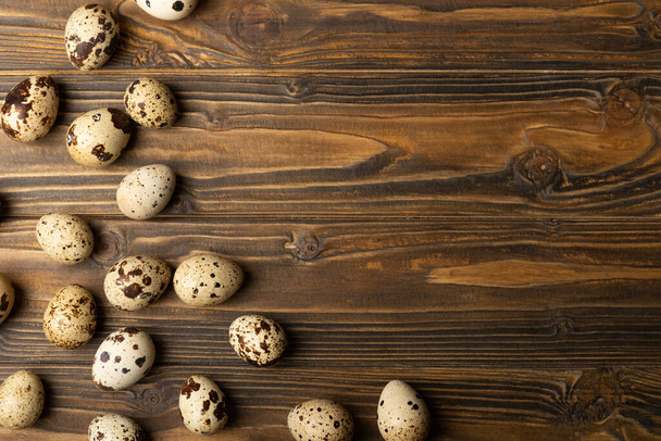 Huevos frescos de codorniz en una mesa de madera marrón. Los huevos crudos de codorniz se cierran. Comida saludable. El concepto de preparación para cocinar. Lugar para el texto. Lugar para copiar. - Foto, Imagen
