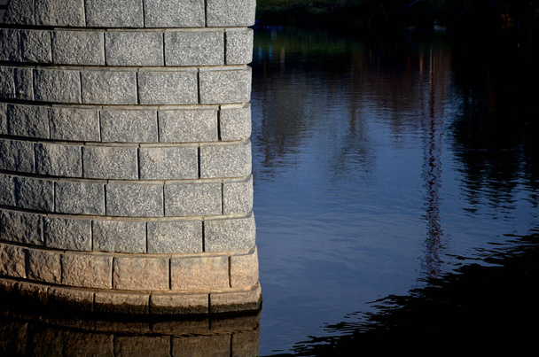 Boylam şeritli düz bir taş duvarın kombinasyonu pürüzsüz granit blokların kemerini takip eder. Sütunlar, sislerin ve taş duvarların çitleri. yerel taş ustası - Fotoğraf, Görsel