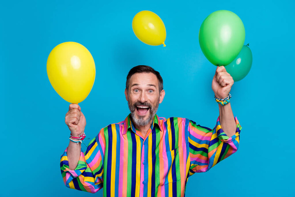 Photo of overjoyed man rejoice enjoy party work corporate celebrate anniversary hold two helium balloons isolated on blue color background. - Photo, Image