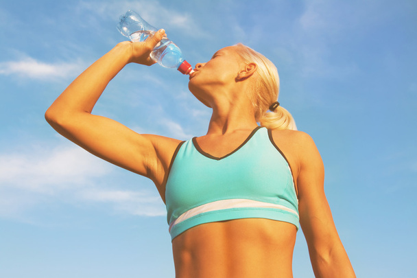 Prachtige blond meisje drinkwater - Foto, afbeelding