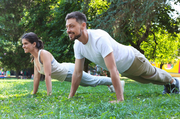 Man and woman doing morning exercise in park - Foto, Imagem