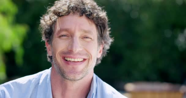 Portrait, mature face and happy man in garden, park and nature for fresh air, freedom or relax with happiness in Germany outdoors. Headshot of smile, funny and laughing guy enjoying summer sunshine. - Footage, Video