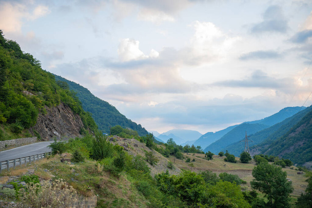 gorge between mountains green bushes cloudy sky. High quality photo - Fotografie, Obrázek