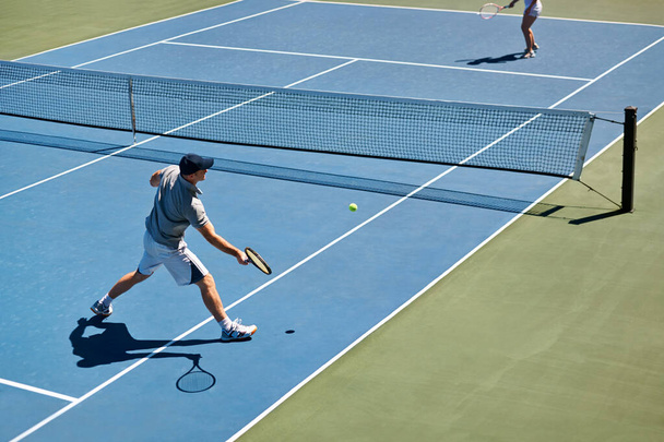 Showing up to every tennis practice. a man trying to return a ball on a tennis court - Photo, Image