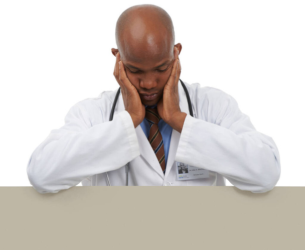 Überarbeitet und müde. Ein junger Arzt stützt sich auf Kopierraum und sieht müde aus - Foto, Bild