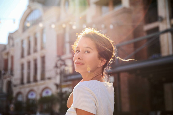 Portrait of happy young woman outdoors on sunny day - Foto, afbeelding