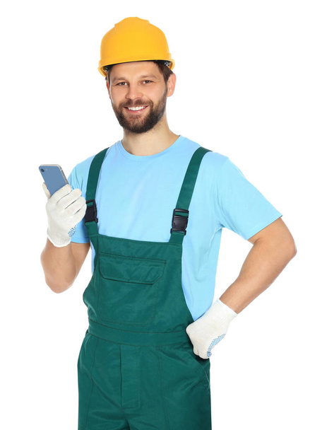 Professional repairman in uniform with smartphone on white background - Foto, Imagen