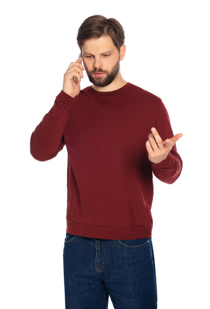 Man talking on smartphone against white background - Foto, afbeelding