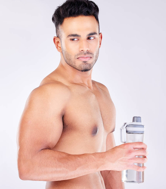 Fit, strong and workout break and water bottle with a man ready to drink water on a grey studio background. Bodybuilder, drinking water and exercise or training break for thirsty hydration. - Photo, Image