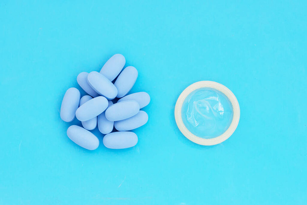 Kondomi HIV:n ehkäisyyn käytettävien PrEP (pre-Exposure Prophylaxis) sinisten pillereiden kanssa  - Valokuva, kuva