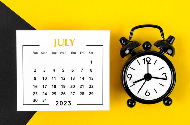 July 2023 Monthly calendar for 2023 year with black colour alarm clock on beautiful background. - Foto, Bild