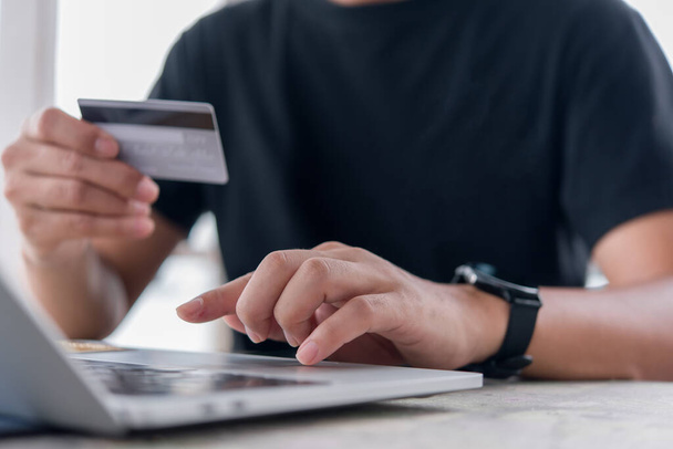 オンラインショッピング電子商取引やインターネットバンキングの概念.クレジットカードを保持し、ラップトップを使用して人の手.ビジネスファイナンスの支払いと会計. - 写真・画像