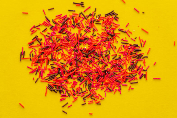 Top view of colorful sprinkles on yellow background  - Foto, Imagem