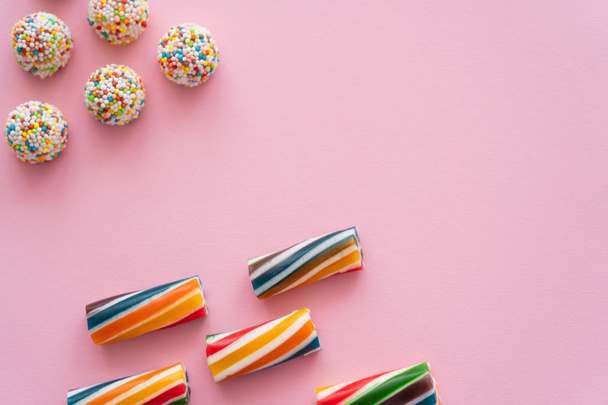 Flat lay with striped and colorful candies on pink background  - Φωτογραφία, εικόνα