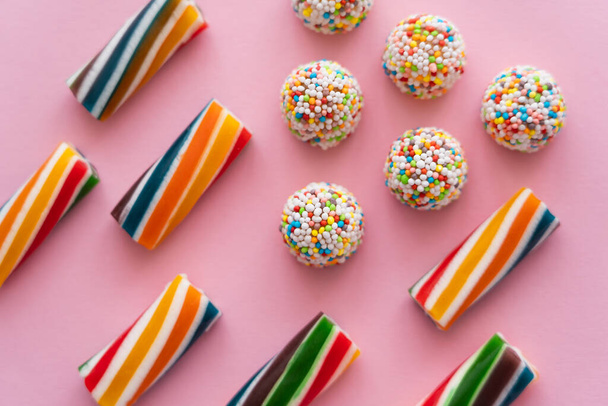 Flat lay with colorful blurred sweets on pink background  - Foto, Imagem