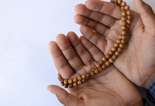 Asian young boy prays with open hands on a white background. Boy praying to god with the praying beads. - Foto, afbeelding