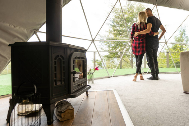 a couple in geo dome tents. Cozy, camping, glamping, holiday, vacation lifestyle concept. Outdoors cabin, scenic background - Foto, afbeelding