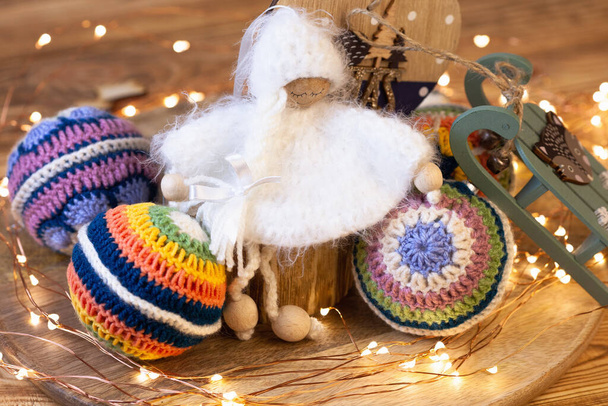 Noel meleği işlemeli oyuncak. Noel ağacı süslemesi. Etrafı renkli toplar ve Noel ışıklarıyla çevrili. - Fotoğraf, Görsel