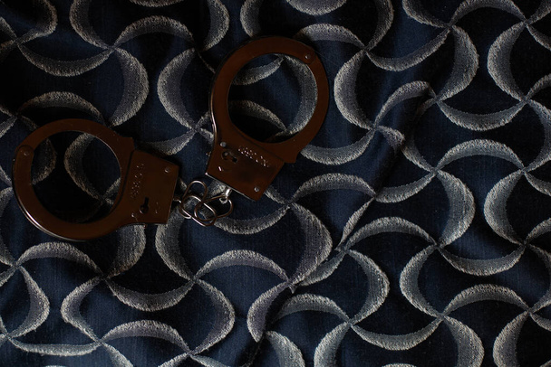 Classic chain handcuffs on black background. - Foto, afbeelding