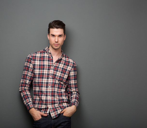 Relaxed young man with checkered shirt posing  - Foto, afbeelding