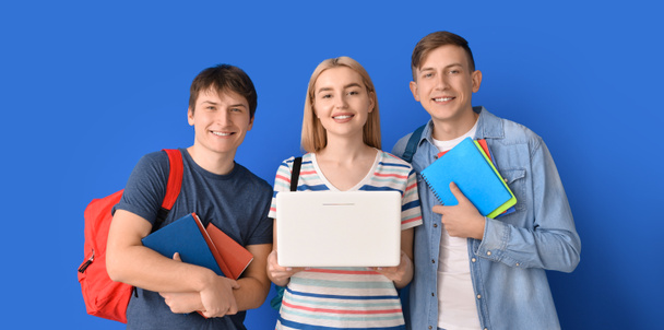 Estudiantes con portátil sobre fondo azul - Foto, Imagen