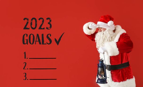 Santa Claus and blank to-do list for year 2023 on red background - Photo, Image