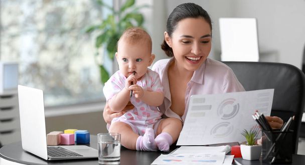 Dolgozó anya a babájával a modern irodában - Fotó, kép