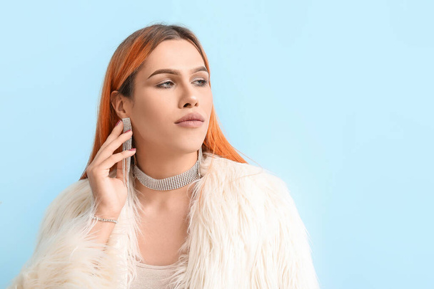 Young transgender woman with beautiful manicure on blue background - Photo, Image