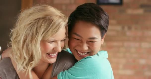 Couple, lgbtq and lesbian hug, kiss and love in home, interracial and partner together with happy smile. Friends, gay and queer people together, happiness and care in house with care, laugh and women. - Footage, Video