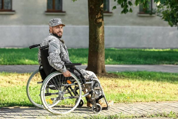 Young soldier in wheelchair outdoors - Photo, Image