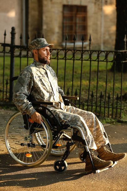 Young soldier in wheelchair on street - Фото, зображення