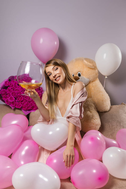 Attractive blonde woman with a large glass of champagne. Birthday - Zdjęcie, obraz