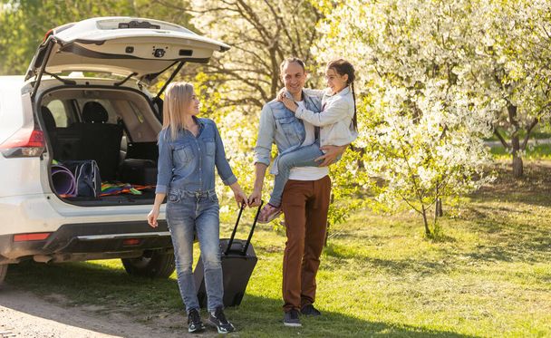 parents and child stopped for break by car. happy family travels by car. Car travel concept. healthy family. - Valokuva, kuva