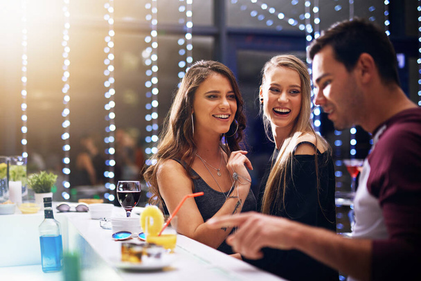 Feest, mensen en cocktail in een club voor verjaardag, feest en plezier hebben in een nachtclub, lachen en praten. Vrienden, kroeg en happy hour door man en vrouw vieren evenement, nieuwjaar of weekend. - Foto, afbeelding