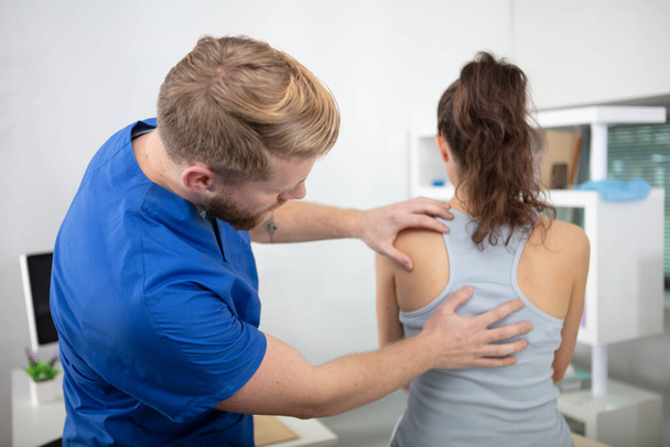 physiotherapist working with patient in clinic - Foto, afbeelding