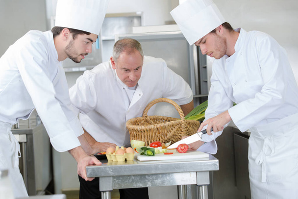chef overseeing trainees prepping vegetables - Φωτογραφία, εικόνα
