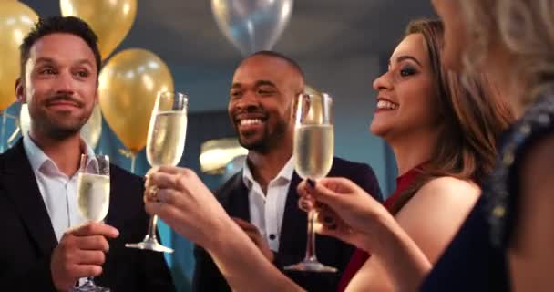 Vrienden, toast champagne en feest met diversiteit, glimlach en geluk in de nacht met ballonnen in huis. Multiculturele groep, mensen vieren feest en blij met wijn, glas en sociaal succes in huis. - Video