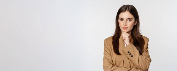 Kép üzletasszony gondolkodás, vállalati nő néz figyelmes, döntéshozatal döntés, álló barna öltöny fehér háttér. - Fotó, kép