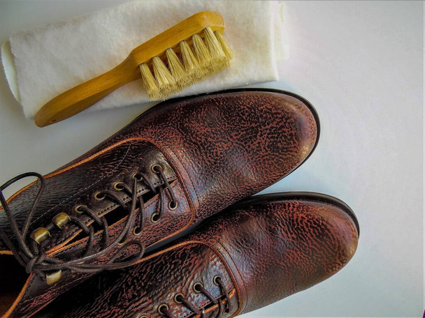 Men's  shoes and a brush for shoes on a light background. Leather shoe care, men's shoe cleaning - Photo, Image