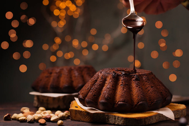 Chocolade Kerst cupcake met noten en chocolade glazuur op een donkere achtergrond - Foto, afbeelding