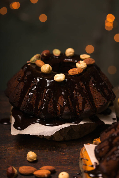 Chocolade Kerst cupcake met noten en chocolade glazuur op een donkere achtergrond - Foto, afbeelding