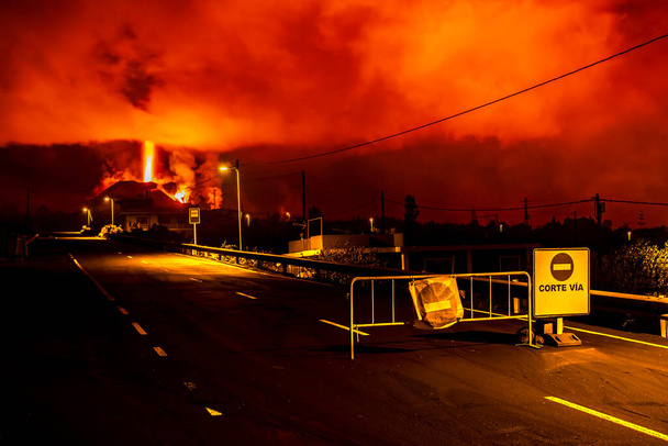 Erupting volcano, cumbre vieja, la Palma. Volcanic eruption at night in December. Police barrier, Mirador de Tajuya viewing point. - Photo, Image