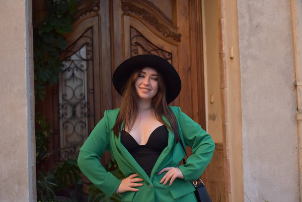 kaunis nuori nainen hattu ja musta mekko poseeraa kadulla - Valokuva, kuva