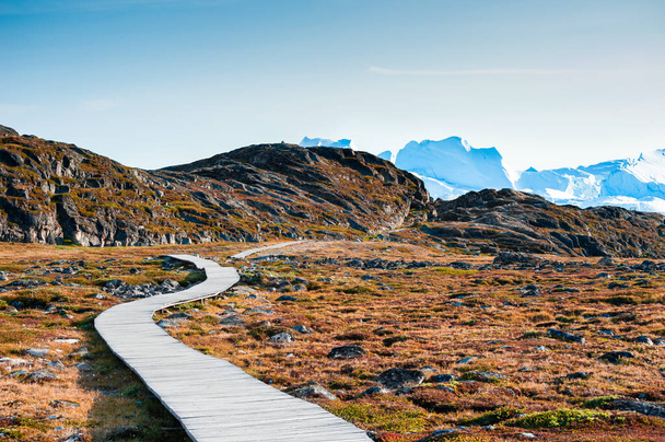 Hiking trail to the Ilulissat icefjord with big icebergs at sunset, western Greenland. Autumn landscape - Foto, Bild