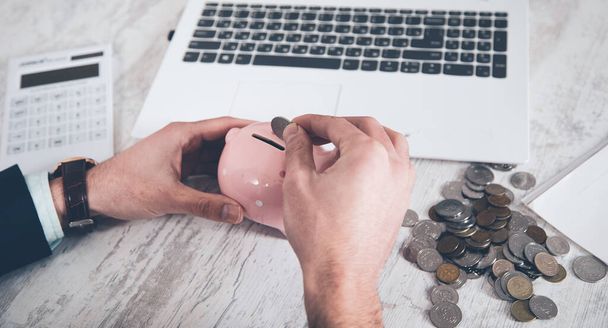 man hand coins with piggy bank and computer - Φωτογραφία, εικόνα